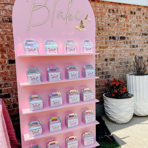 Themed giveaway stand displaying party favour boxes, by La Folie