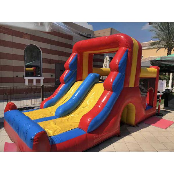 Red, yellow and blue bouncy castle with slide set up outdoors