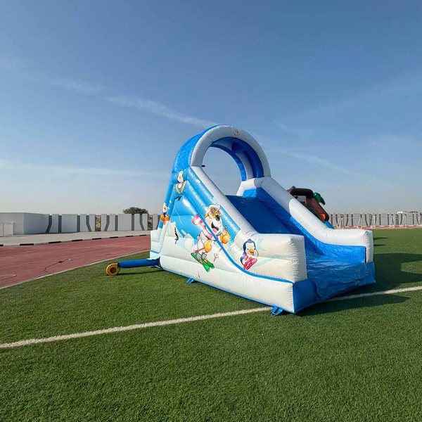 Blue and white inflatable pool slide on artificial grass