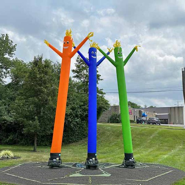 Three colourful inflatable sky dancers outdoors