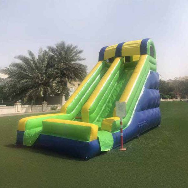 Green, yellow and blue 7 m inflatable slide on a lawn