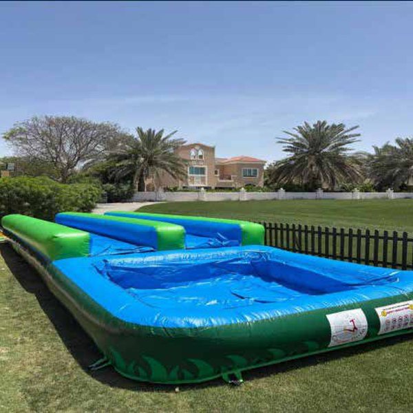 Blue and green inflatable slip and slide on a lawn